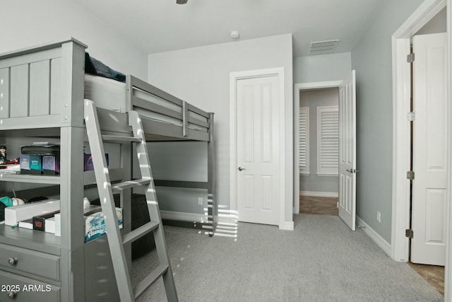 carpeted bedroom featuring visible vents and baseboards