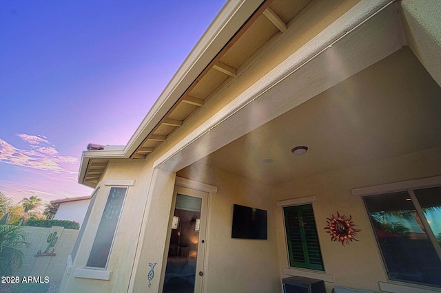 exterior entry at dusk featuring stucco siding