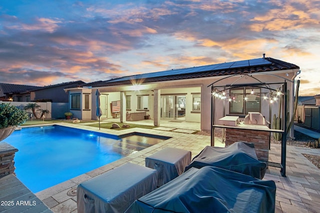 view of pool featuring exterior kitchen, a patio area, a fenced backyard, and a fenced in pool