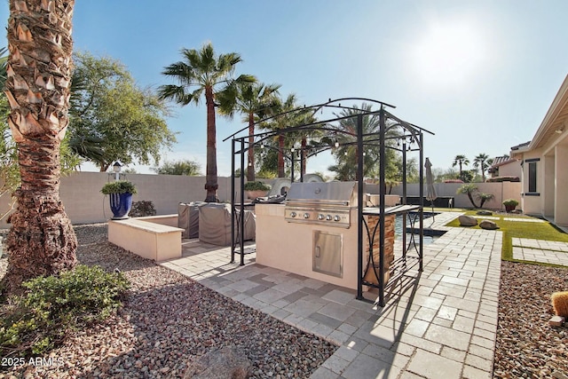 view of patio / terrace with a grill, an outdoor kitchen, and a fenced backyard