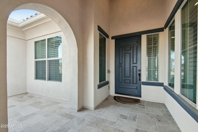 doorway to property featuring stucco siding