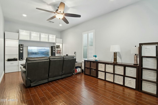 living area with ceiling fan, dark wood finished floors, and visible vents