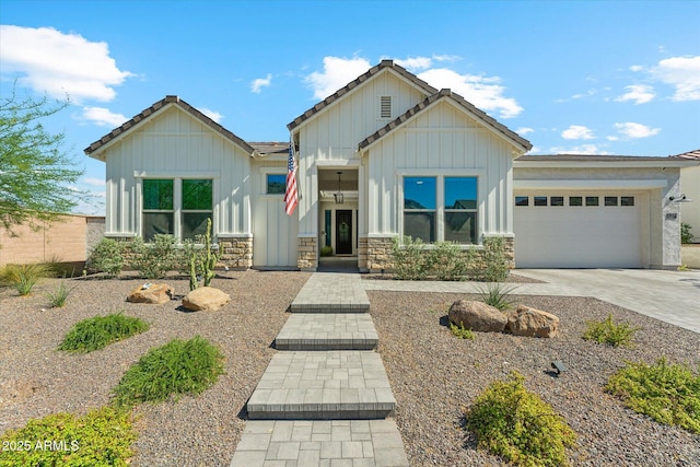 21391 W Mariposa St, Buckeye, AZ 85396 - view of front facade featuring board and batten siding, a garage, driveway, and stone siding