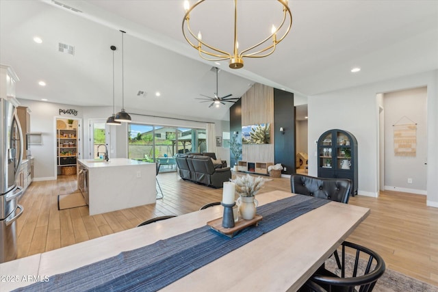 21391 W Mariposa St, Buckeye, AZ 85396 - dining area featuring a chandelier, light wood finished floors, baseboards, vaulted ceiling, and recessed lighting