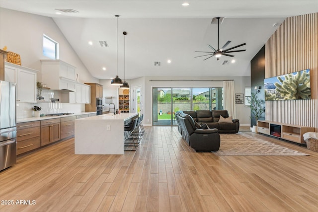 21391 W Mariposa St, Buckeye, AZ 85396 - kitchen featuring high vaulted ceiling, open floor plan, light countertops, stainless steel appliances, and a ceiling fan