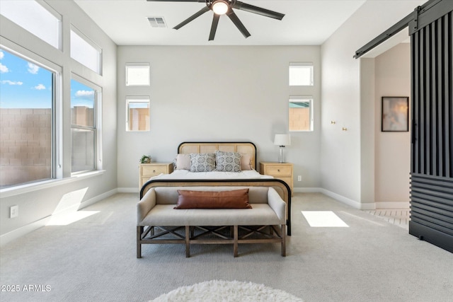 21391 W Mariposa St, Buckeye, AZ 85396 - carpeted bedroom featuring a barn door, multiple windows, baseboards, and ceiling fan
