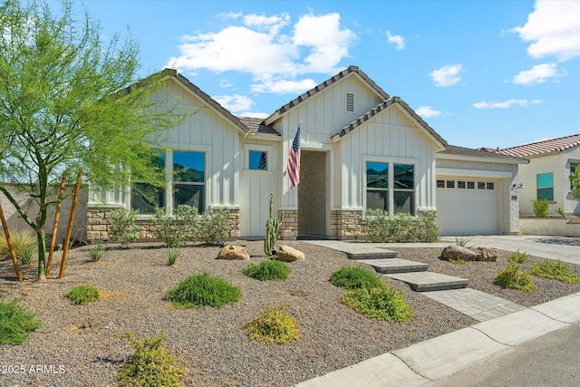 21391 W Mariposa St, Buckeye, AZ 85396 - view of front of house with board and batten siding, a garage, stone siding, a tiled roof, and concrete driveway