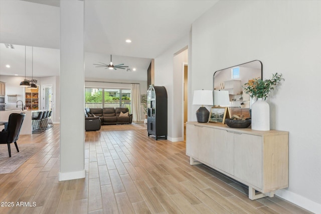 21391 W Mariposa St, Buckeye, AZ 85396 - hall featuring light wood-type flooring, a sink, baseboards, and recessed lighting
