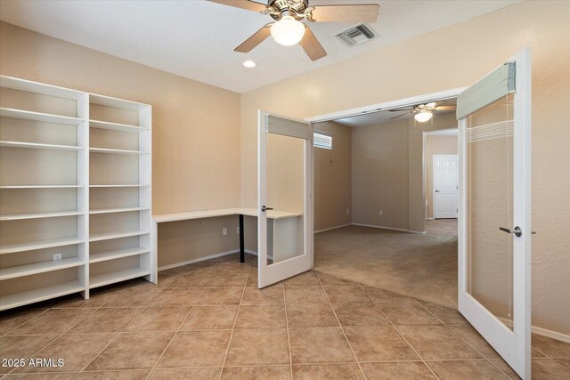 interior space with tile patterned floors, ceiling fan, baseboards, visible vents, and french doors