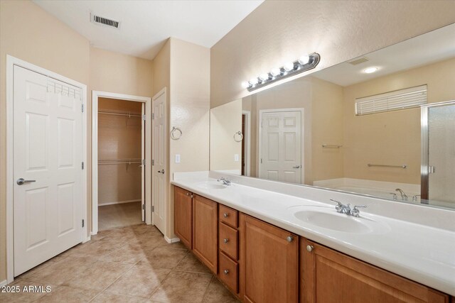 full bathroom featuring a sink, double vanity, visible vents, a garden tub, and tile patterned flooring