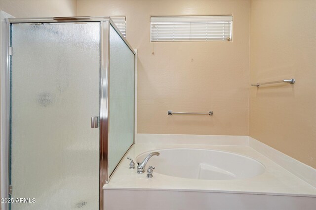 full bath featuring a stall shower and a garden tub