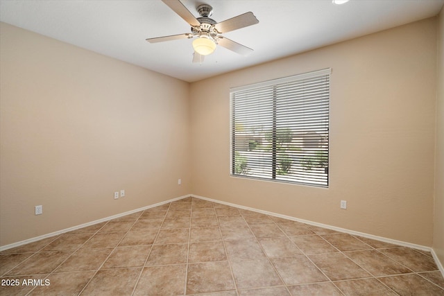 spare room featuring light tile patterned floors, ceiling fan, and baseboards