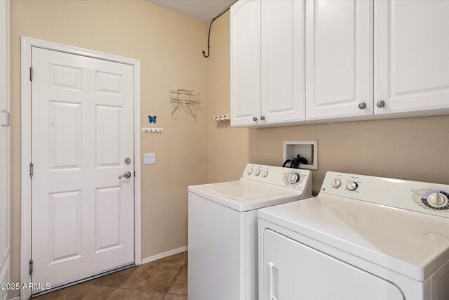 laundry area featuring tile patterned floors, independent washer and dryer, cabinet space, and baseboards