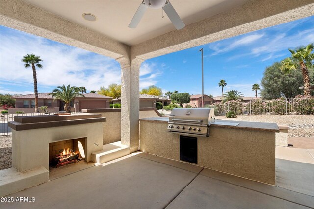 view of patio featuring area for grilling, ceiling fan, fence, a lit fireplace, and a grill