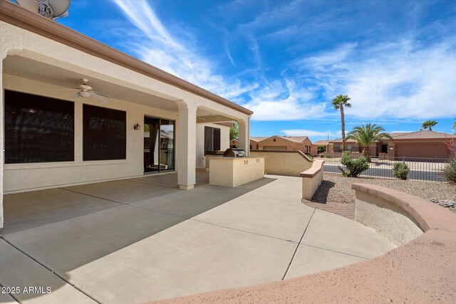 view of patio / terrace featuring area for grilling, ceiling fan, and fence