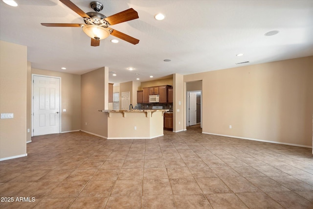 unfurnished living room with recessed lighting, light tile patterned flooring, ceiling fan, visible vents, and baseboards