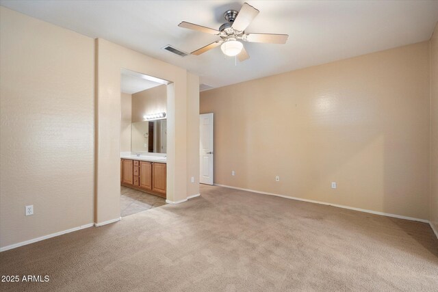 interior space with baseboards, visible vents, light carpet, and ceiling fan