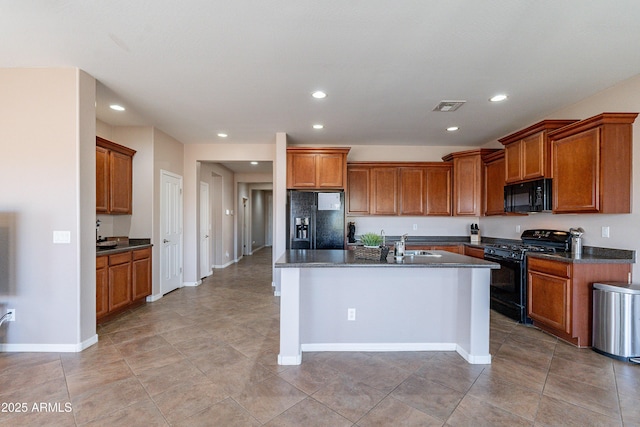 kitchen featuring sink, a center island with sink, and black appliances