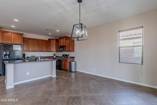 kitchen with sink, an inviting chandelier, decorative light fixtures, a center island with sink, and black appliances