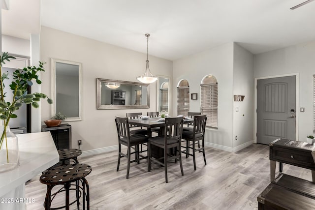 dining room featuring baseboards and light wood-type flooring