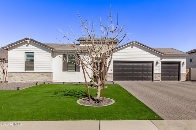 ranch-style home with brick siding, decorative driveway, and a front yard