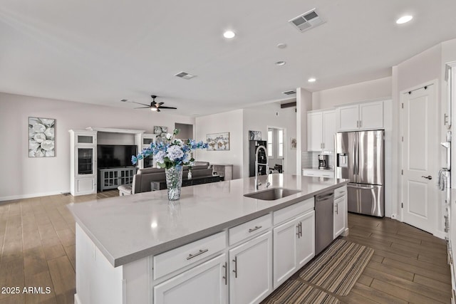 kitchen with dark wood-type flooring, visible vents, stainless steel appliances, and a sink