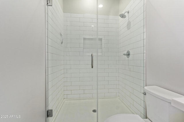 bathroom featuring a shower stall and toilet