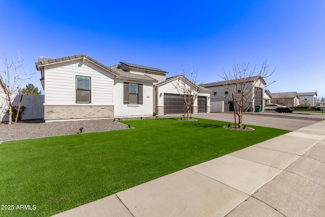 view of front facade with a garage, brick siding, a tile roof, driveway, and a front yard