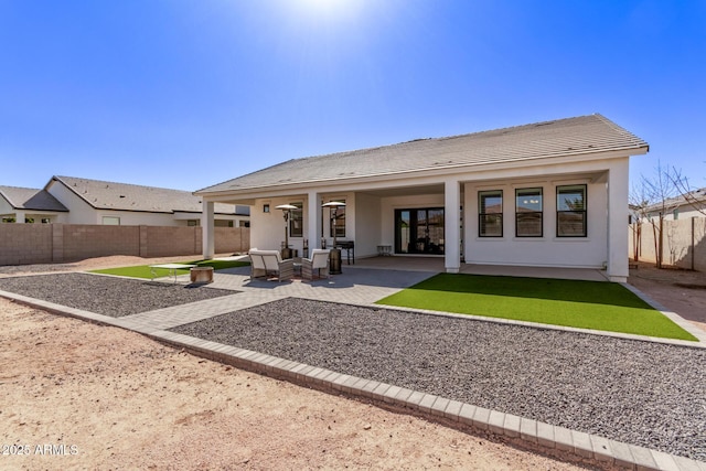 back of house featuring a patio, a fenced backyard, and stucco siding