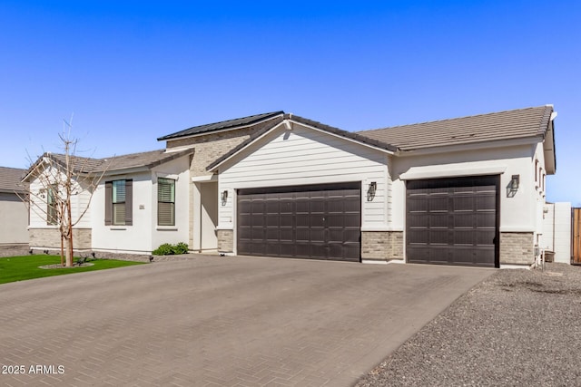 single story home featuring an attached garage and decorative driveway