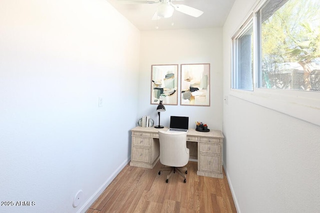 office featuring a ceiling fan, light wood-type flooring, and baseboards