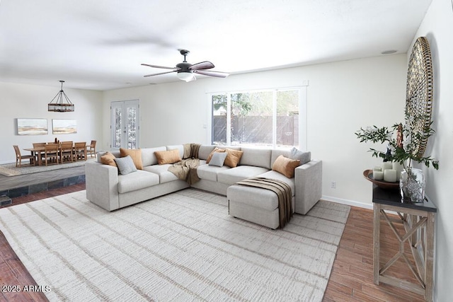 living area with wood finished floors, baseboards, and ceiling fan