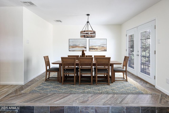 dining area featuring visible vents, baseboards, french doors, an inviting chandelier, and wood finished floors