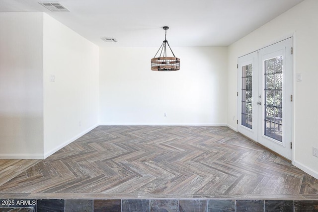 unfurnished dining area with an inviting chandelier, baseboards, visible vents, and french doors