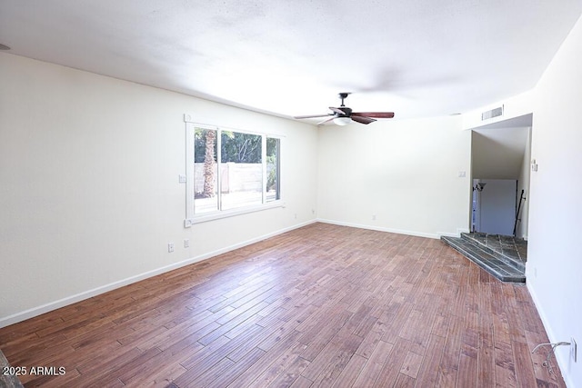 unfurnished living room featuring visible vents, baseboards, wood finished floors, and a ceiling fan