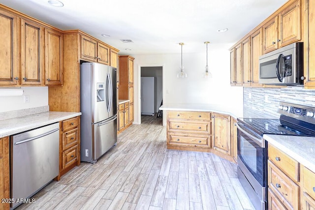 kitchen with visible vents, stainless steel appliances, light wood-style floors, brown cabinets, and backsplash