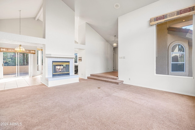 unfurnished living room with a fireplace, a wealth of natural light, light colored carpet, and beamed ceiling