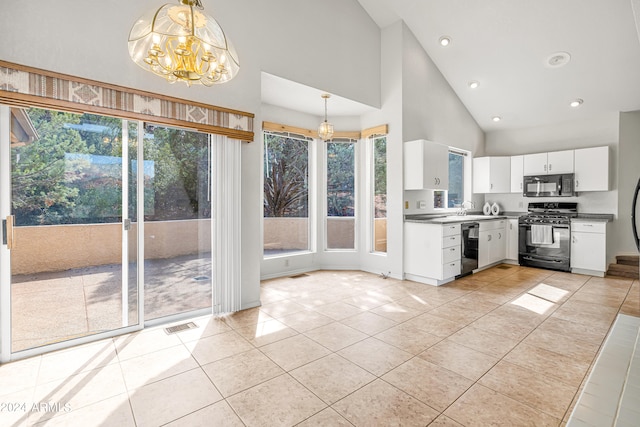 kitchen with hanging light fixtures, black appliances, a wealth of natural light, and white cabinetry