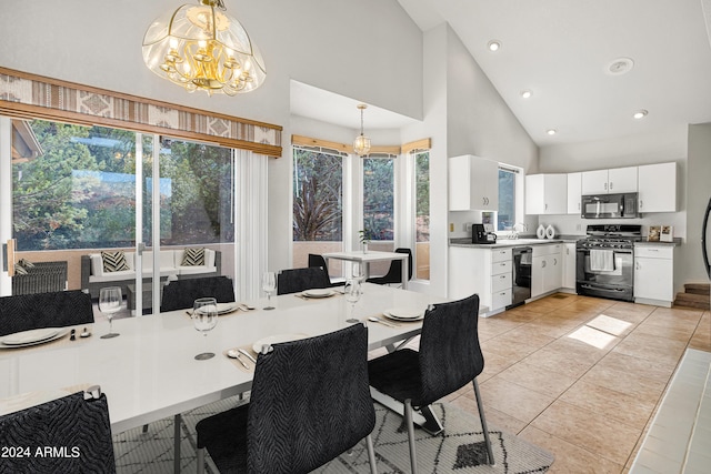 dining area featuring light tile patterned flooring, high vaulted ceiling, a notable chandelier, and sink