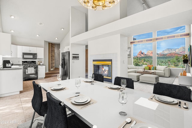 tiled dining room featuring a fireplace and high vaulted ceiling