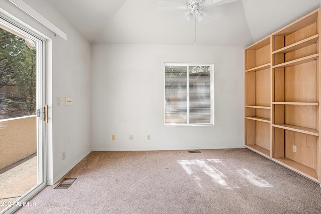 carpeted empty room featuring ceiling fan, lofted ceiling, and a wealth of natural light