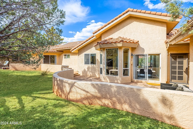 back of property featuring a patio and a yard