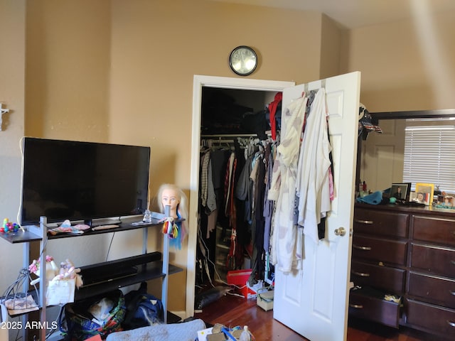 bedroom with dark hardwood / wood-style floors and a closet