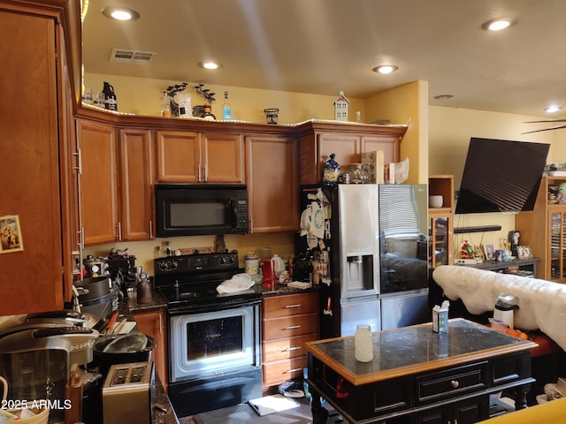 kitchen featuring stainless steel fridge with ice dispenser, a kitchen island, and electric range