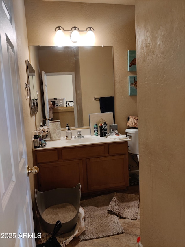 bathroom featuring vanity, toilet, and tile patterned flooring