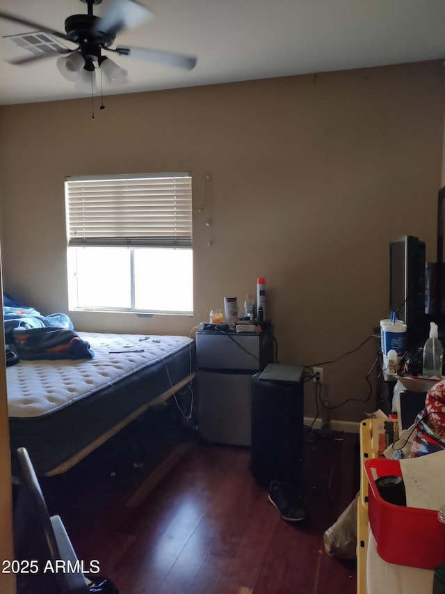 bedroom with fridge and dark hardwood / wood-style floors