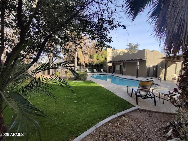 view of pool with a patio and a lawn