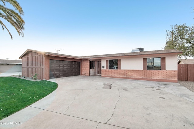 ranch-style home featuring a garage and a front lawn