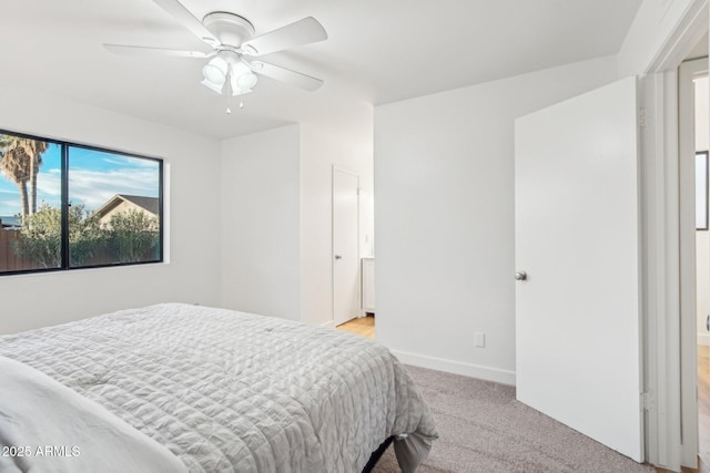 carpeted bedroom with connected bathroom and ceiling fan