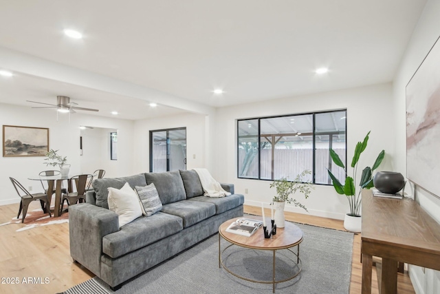 living room with ceiling fan and light wood-type flooring